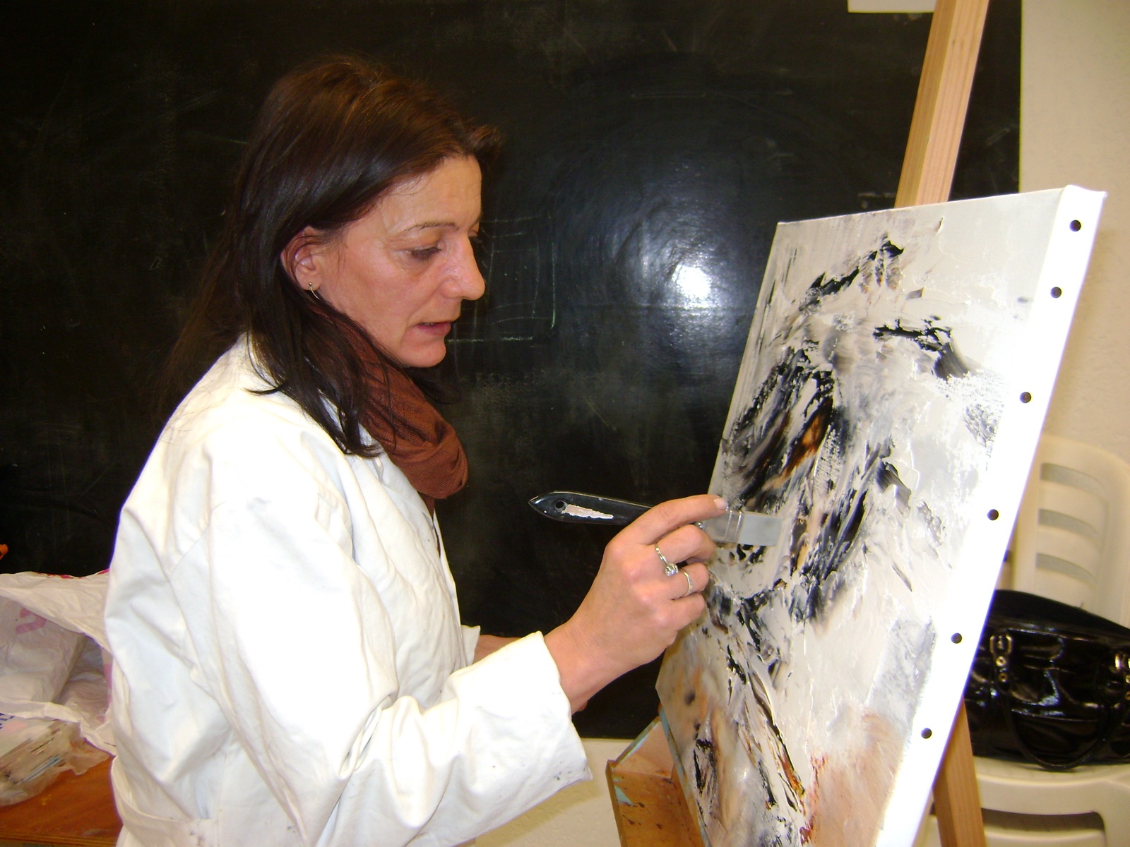 Régine Gardan travaillant une toile abstraite au couteau dans son atelier